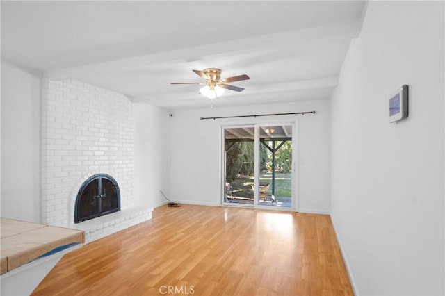 unfurnished living room with a ceiling fan, a fireplace, light wood-style flooring, and baseboards