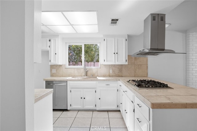 kitchen featuring stainless steel appliances, white cabinetry, ventilation hood, and decorative backsplash