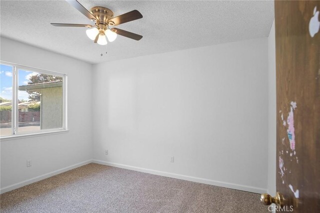 spare room featuring ceiling fan, a textured ceiling, and carpet flooring