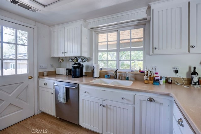 kitchen with light wood-type flooring, sink, dishwasher, and white cabinetry