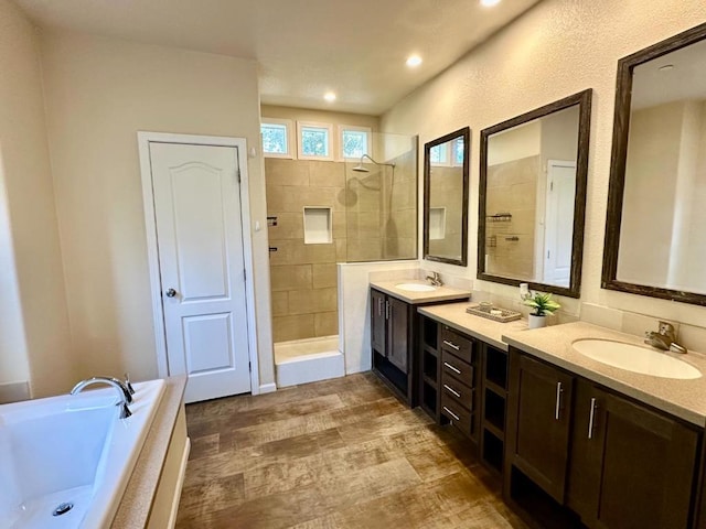 bathroom with separate shower and tub, hardwood / wood-style flooring, and vanity