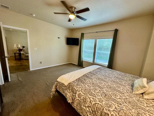 bedroom with ceiling fan and dark colored carpet