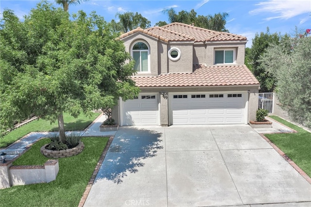 mediterranean / spanish home featuring a garage and a front lawn