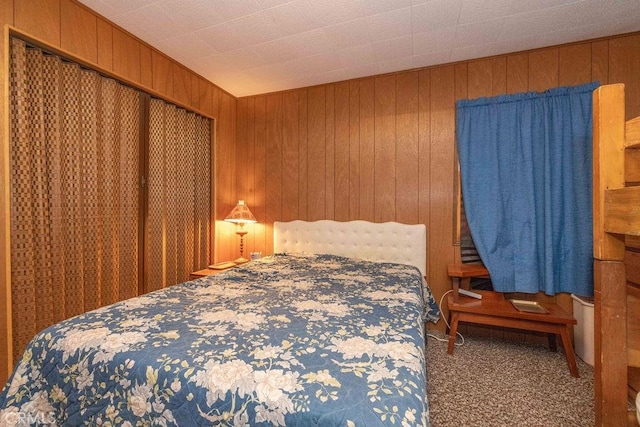 bedroom with wood walls and carpet flooring