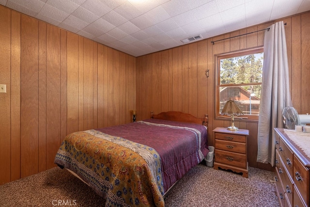 bedroom featuring wood walls and light colored carpet