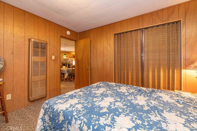 carpeted bedroom with wooden walls and a closet