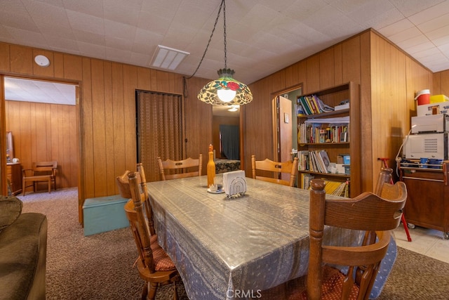 carpeted dining room with wood walls