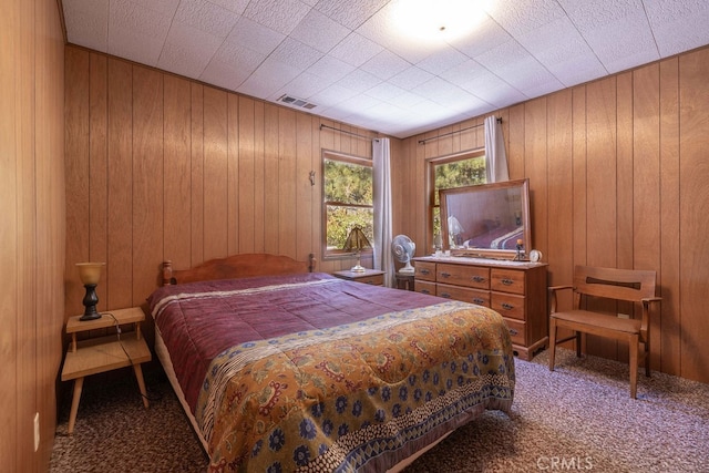 bedroom with wood walls and carpet