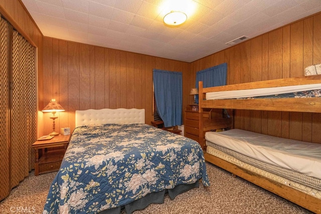 carpeted bedroom with wood walls