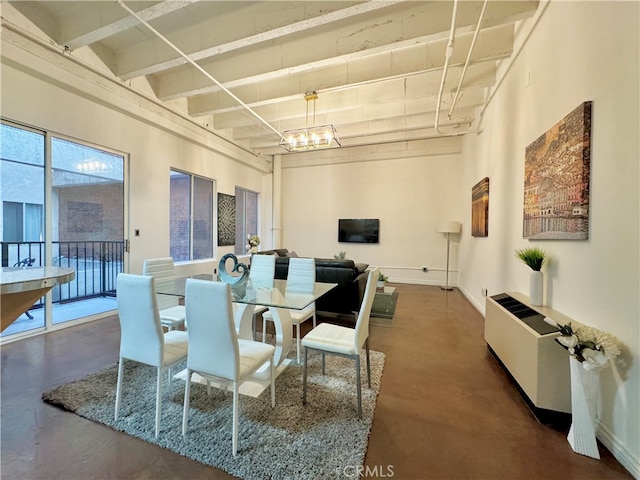 dining area featuring a notable chandelier and a high ceiling