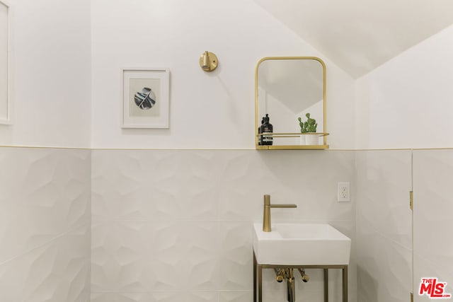 bathroom with sink and tile walls