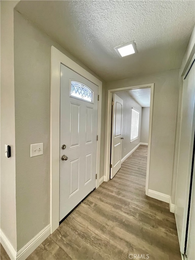 entrance foyer featuring a textured ceiling and light wood-type flooring