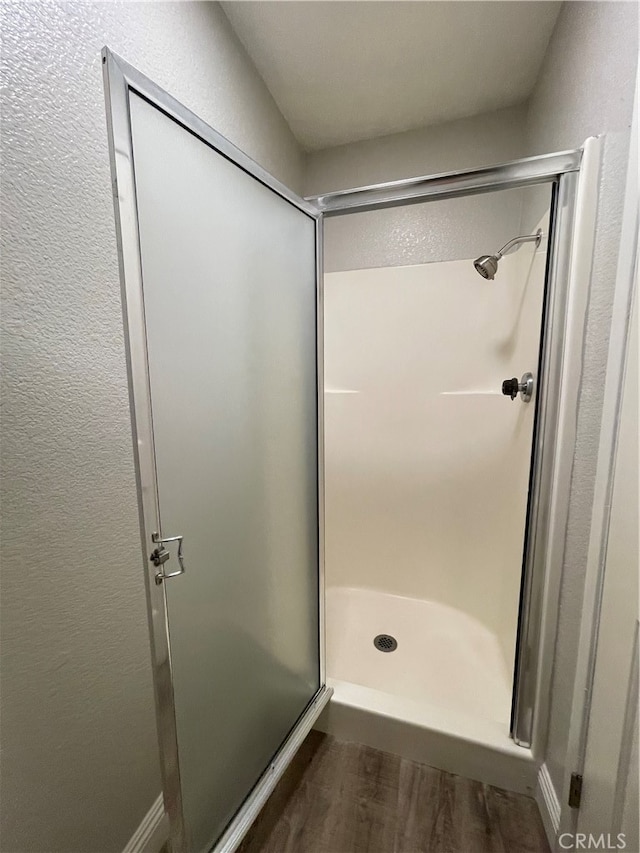 bathroom featuring hardwood / wood-style floors and an enclosed shower