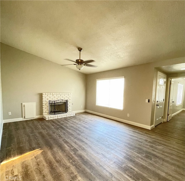 unfurnished living room featuring a textured ceiling, dark hardwood / wood-style floors, and ceiling fan