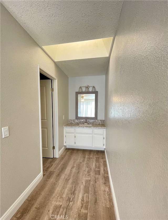 bathroom featuring a textured ceiling, vanity, and hardwood / wood-style floors