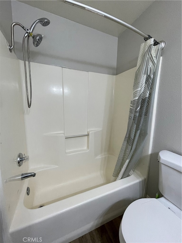 bathroom with shower / bath combination with curtain, wood-type flooring, and toilet