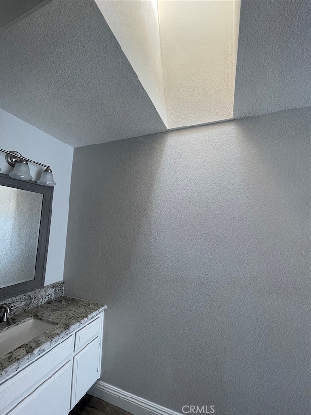 bathroom featuring a textured ceiling and vanity