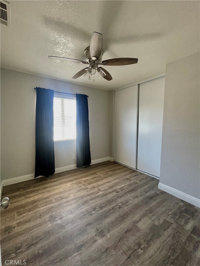 empty room featuring a textured ceiling, ceiling fan, and hardwood / wood-style flooring