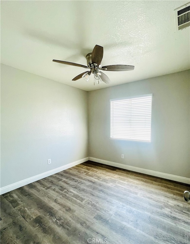 spare room featuring ceiling fan and dark hardwood / wood-style floors