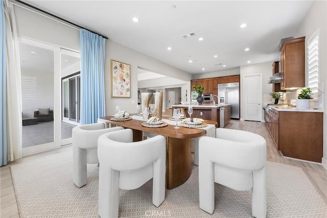 dining room with light hardwood / wood-style floors and sink