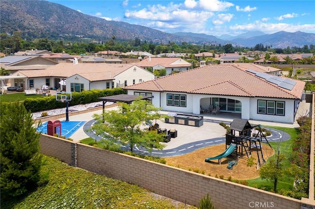 back of property featuring a playground and a mountain view