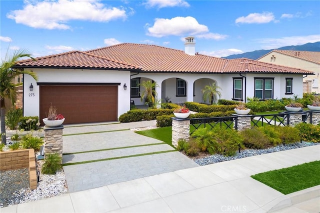 mediterranean / spanish-style house with a mountain view and a garage