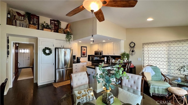 dining area with ceiling fan, vaulted ceiling, and dark hardwood / wood-style flooring