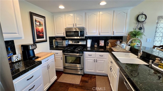 kitchen featuring white cabinets, sink, appliances with stainless steel finishes, and dark wood-type flooring