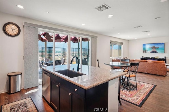 kitchen featuring dishwasher, visible vents, a sink, and wood finished floors