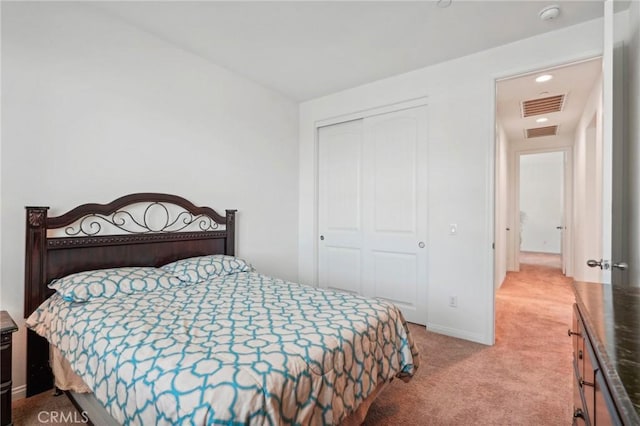 carpeted bedroom with a closet, visible vents, and baseboards