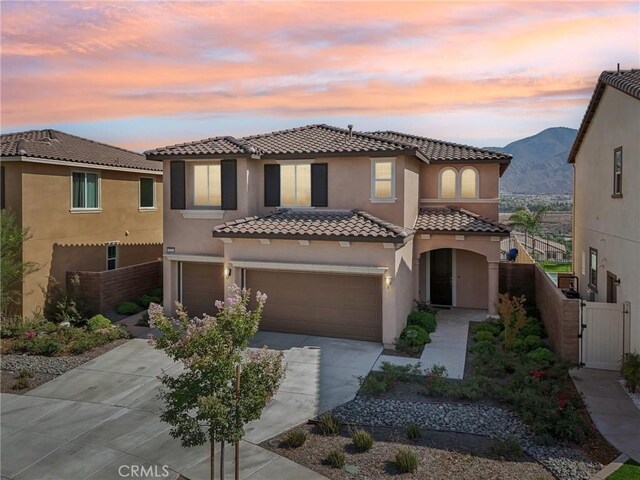 mediterranean / spanish-style house with a garage and a mountain view