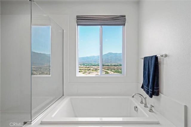 bathroom with a garden tub and a mountain view