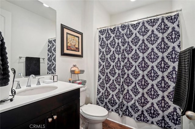 full bathroom with wood finished floors, vanity, and toilet