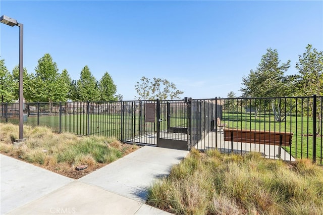 view of gate featuring fence and a yard