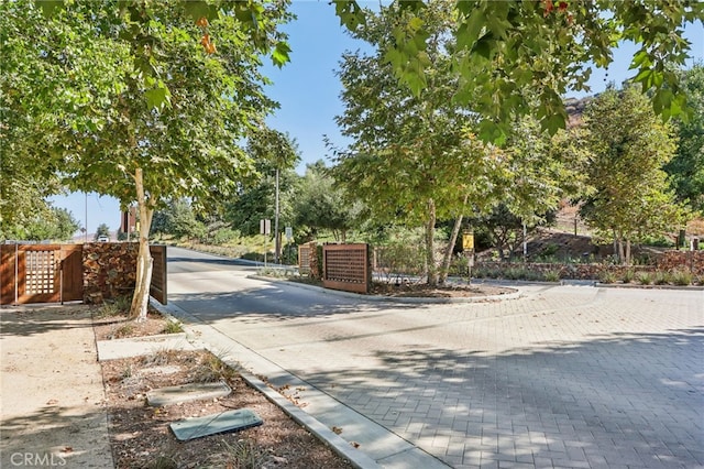 view of street with curbs and a gated entry