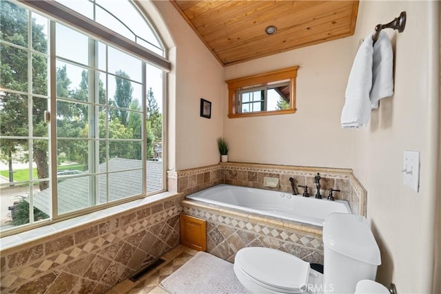 bathroom with vaulted ceiling, wooden ceiling, tile patterned flooring, tiled bath, and toilet