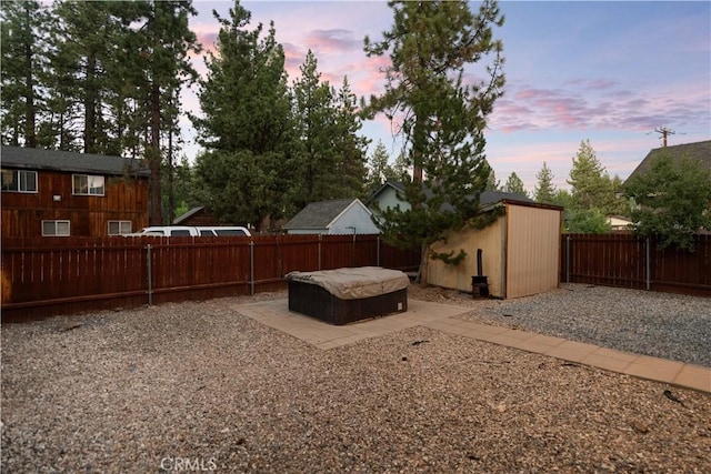 yard at dusk featuring a patio area and a storage shed