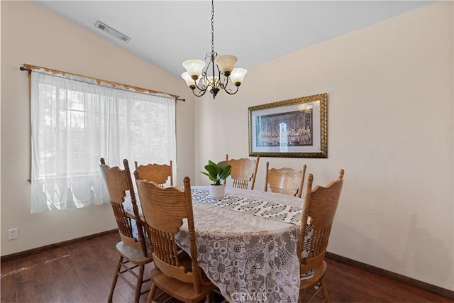 dining space featuring a chandelier, vaulted ceiling, and dark wood-type flooring