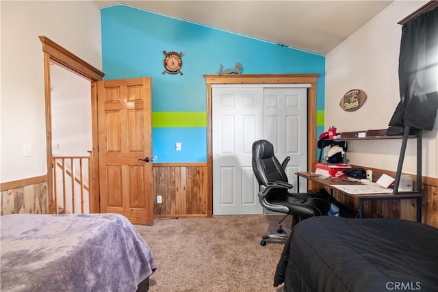 bedroom featuring wood walls, a closet, carpet floors, and lofted ceiling