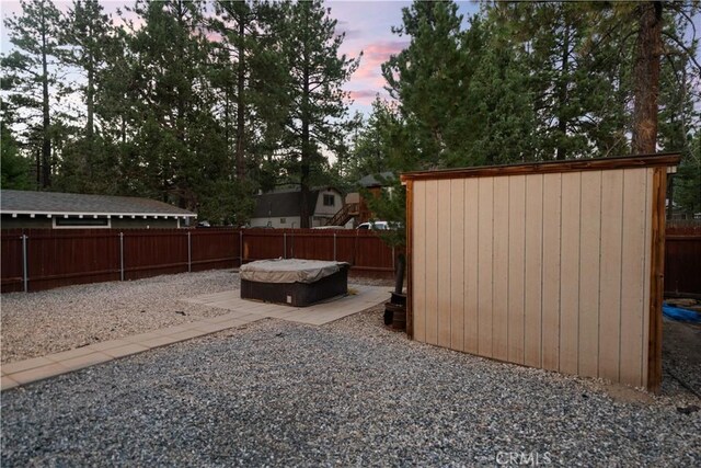 yard at dusk with a hot tub