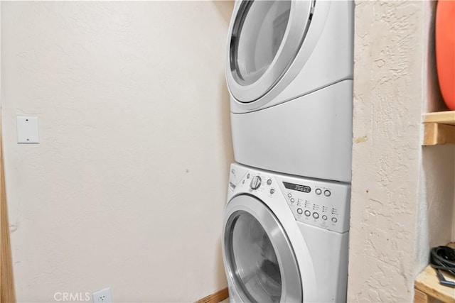 clothes washing area featuring stacked washing maching and dryer