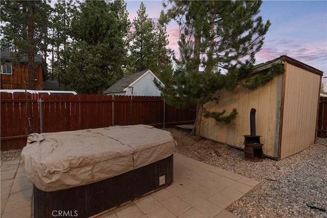 exterior space featuring a hot tub and a storage shed