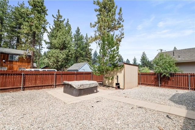 view of yard with a shed and a hot tub