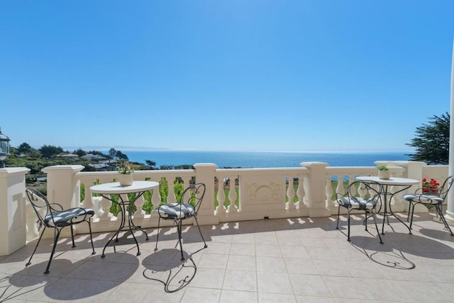 view of patio with a balcony and a water view