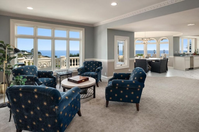 carpeted living room featuring plenty of natural light, a water view, a chandelier, and ornamental molding