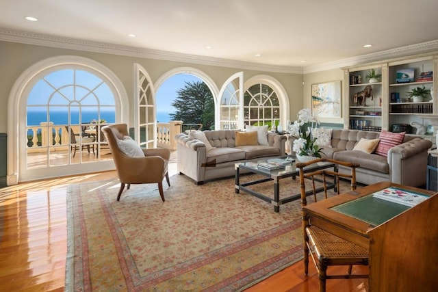 living room featuring crown molding, a water view, and light hardwood / wood-style floors