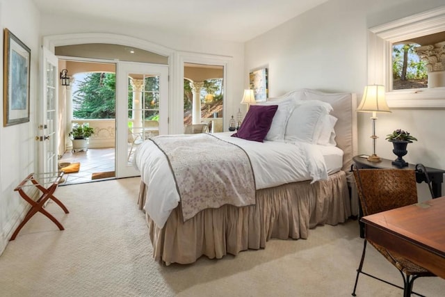 bedroom featuring access to exterior, light carpet, and multiple windows