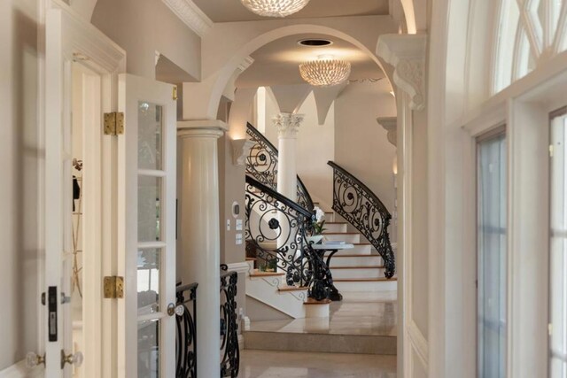 entrance foyer with a chandelier and ornate columns