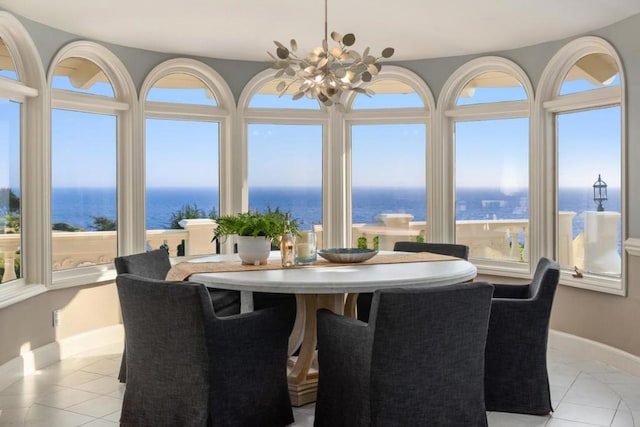 tiled dining space featuring a water view and a notable chandelier