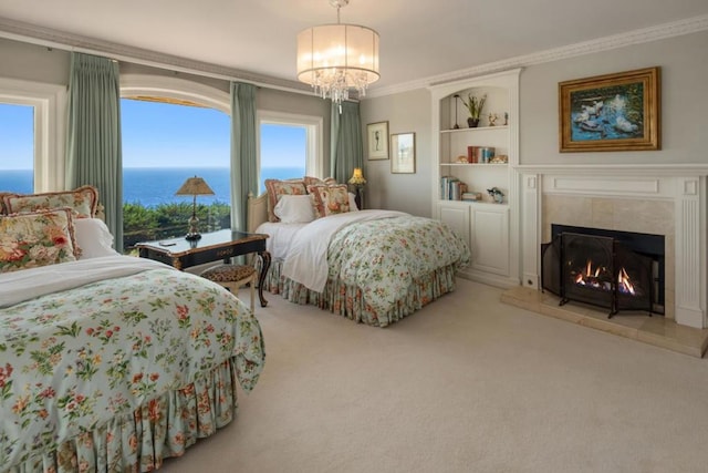 bedroom with carpet flooring, a water view, a tile fireplace, and ornamental molding